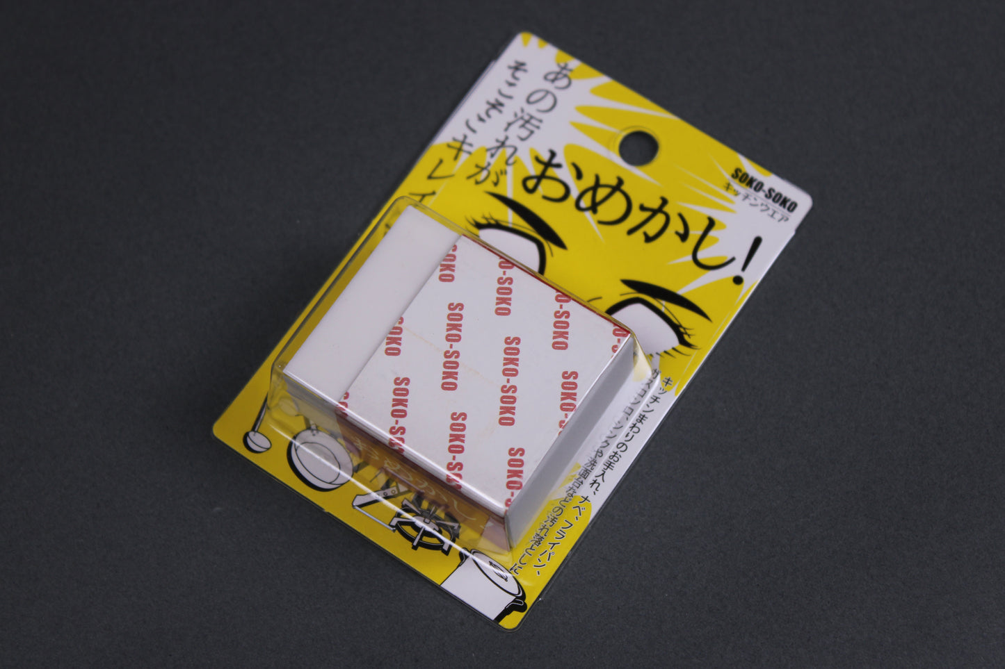 Soko Soko Naniwa rust eraser white rectangular block shape semi surrounded by paper wrap in clear plastic holder attached to product paper with kanji