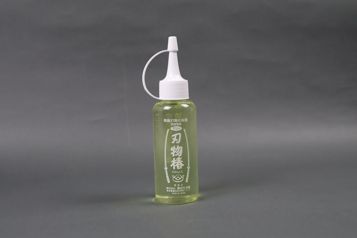 tasteless odorless high quality oil to prevent rusting oxidization on kitchen knives upright shot shimmering light yellow body screw on dropper top white with grey background