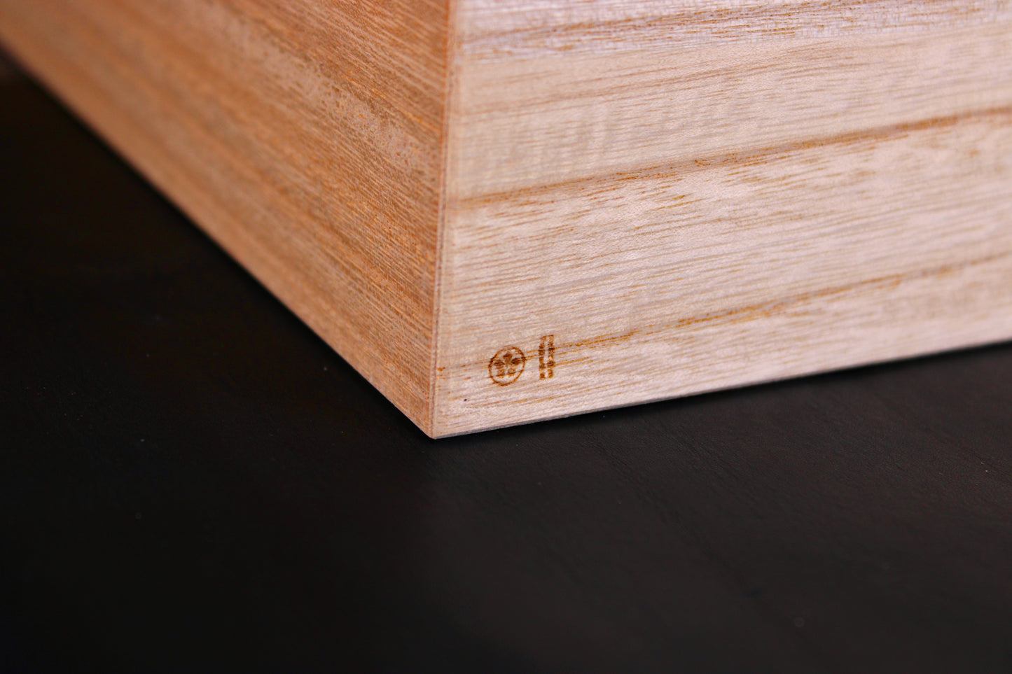 close up of tall rectangular paulownia wood rice box showing azmaya brand logo dark grey background