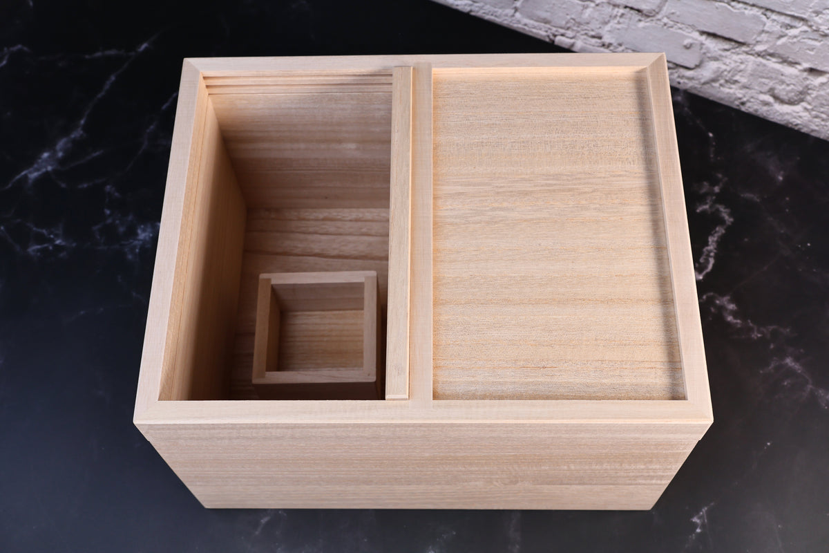 Overhead view of the Azmaya rice bin interior with the masu measuring cup set in the open compartment