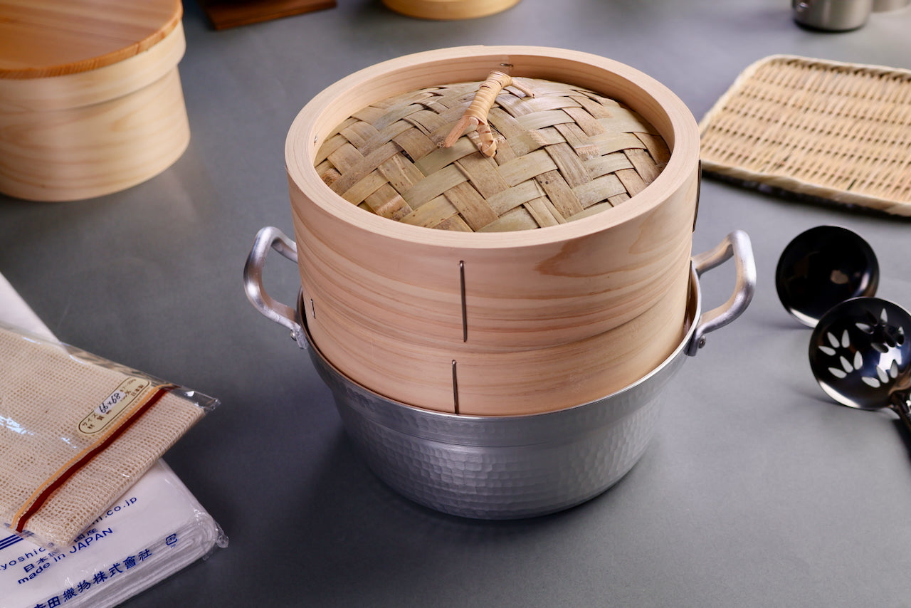 kiso hinoki bamboo steamer kit with seiro steamer pot surrounded by kitchenware steamer cloth plate ohitsu wood grey backdrop
