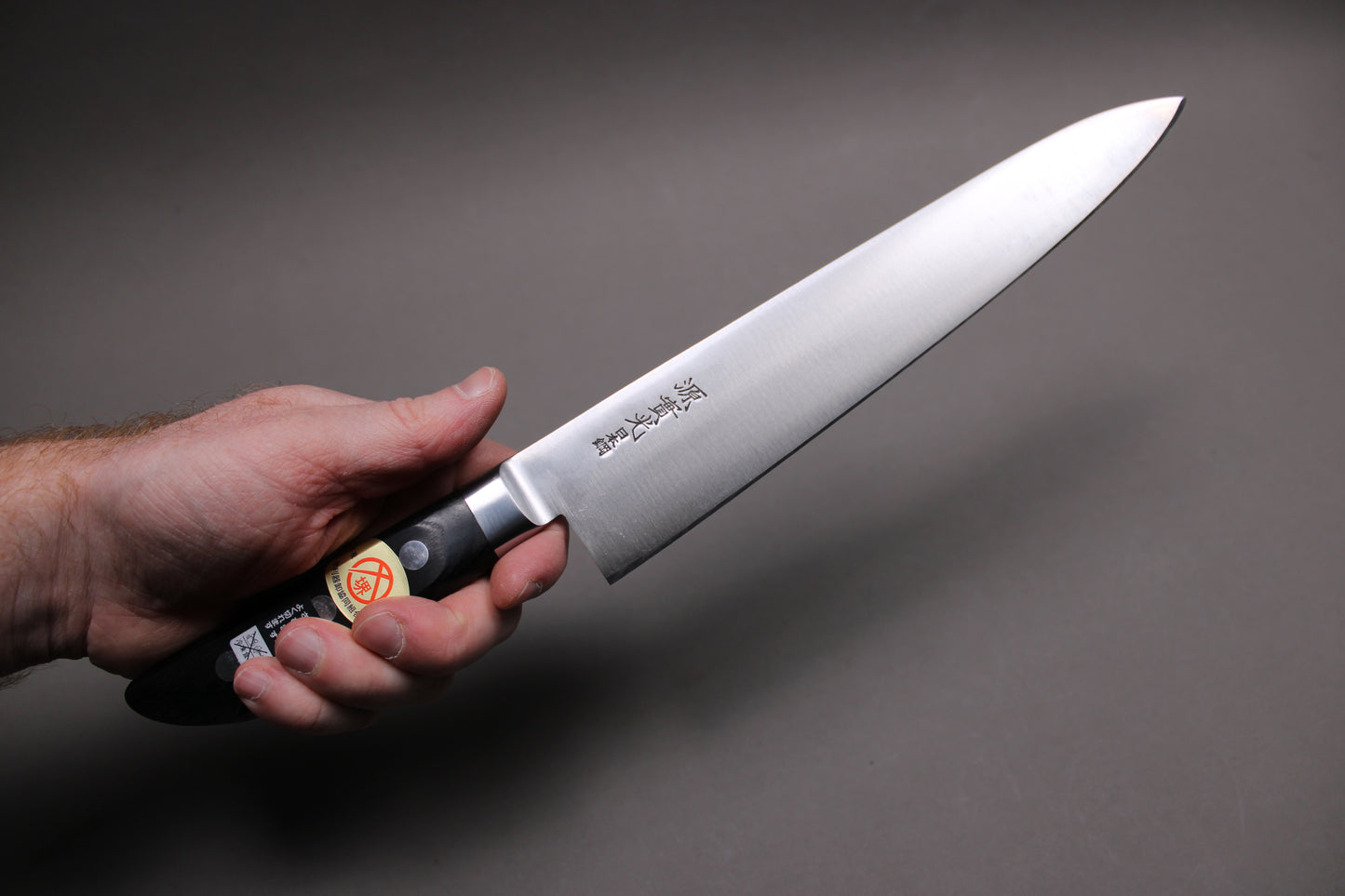 hand holding jikko nihonko carbon steel gyuto 240mm