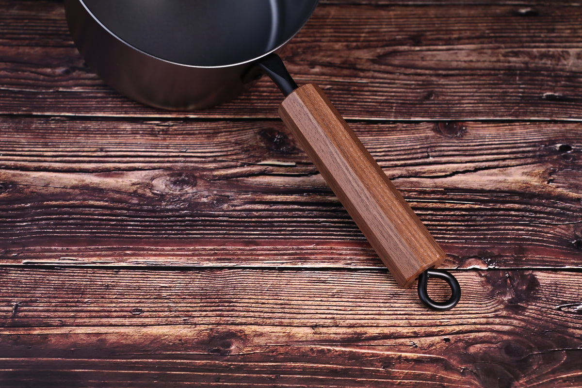 Carbon Steel Nitride saucepan 16cm close-up of octagonal walnut handle and black iron ring on wood surface