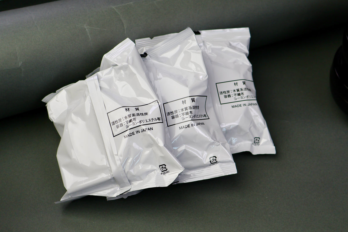 three white plastic kitchen oil filters in grey backdrop