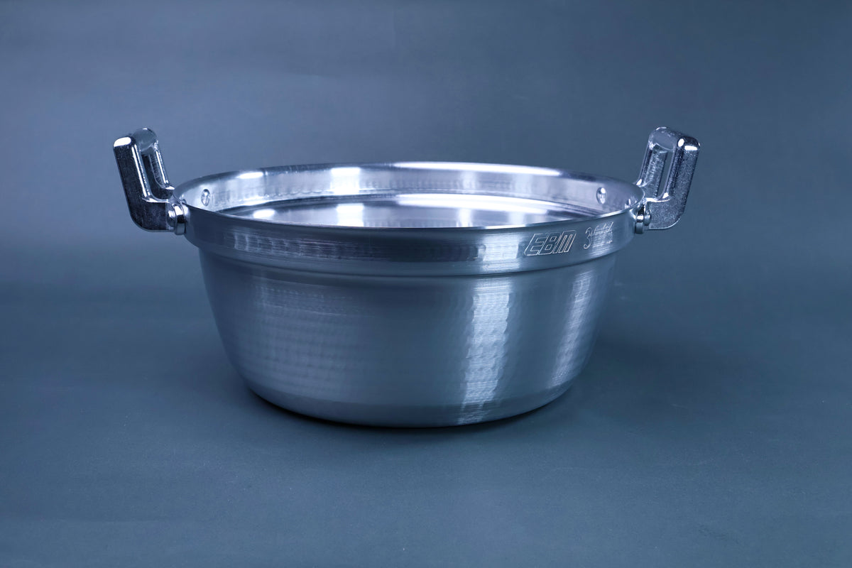 Dantsuki seiro pot 30cm exterior three-quarter view showing hammered aluminum finish and chrome handles on blue-grey background