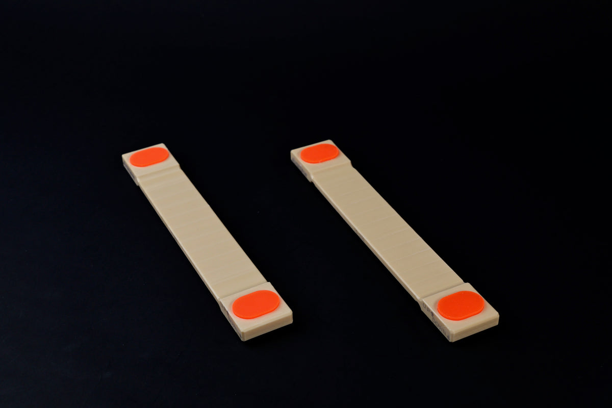 Hasegawa cutting board lifter small — pair laid flat showing orange non-slip grip pads on both ends