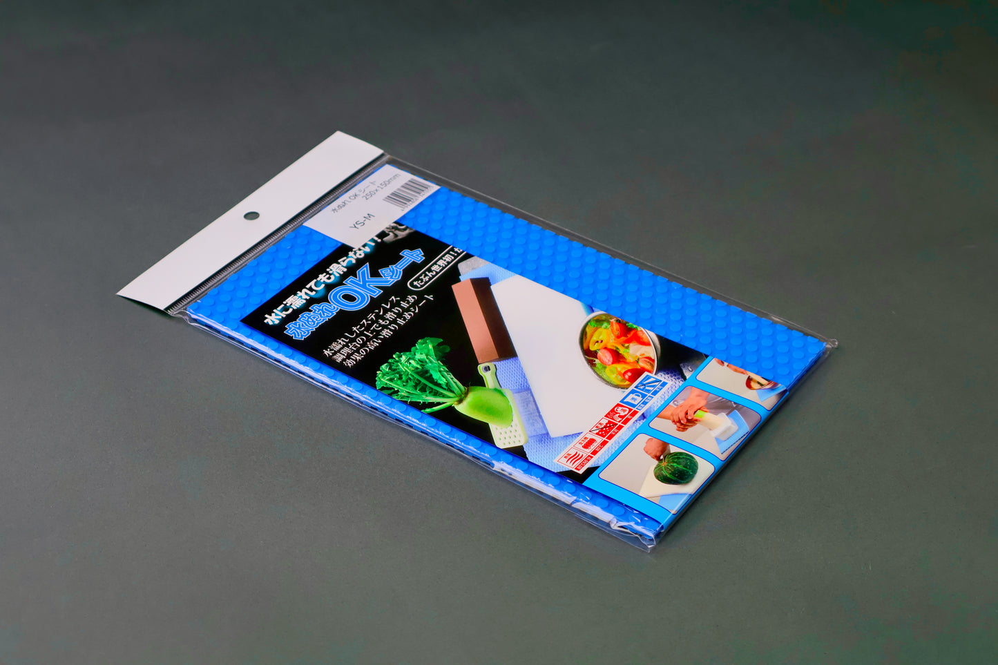 rectangular bright blue embossed mat in plastic product package with white top stripe upc barcode bright hiragana writing and food images on dark grey background