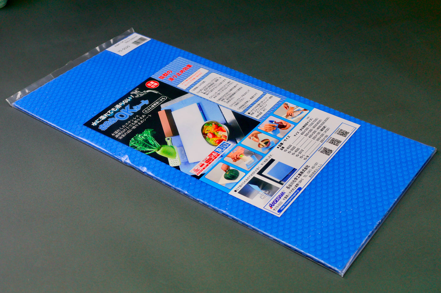 rectangular bright blue embossed mat in plastic product package with white top stripe upc barcode bright hiragana writing and food images on dark grey background