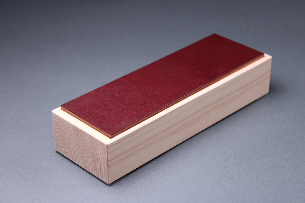 Hinoki espresso leather knife strop — three-quarter view showing burgundy leather surface on hinoki wood base