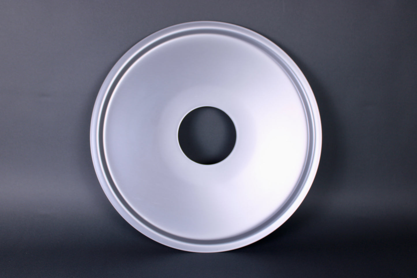 metalic shiny circular steam ring for bamboo steamer center hole dark grey background