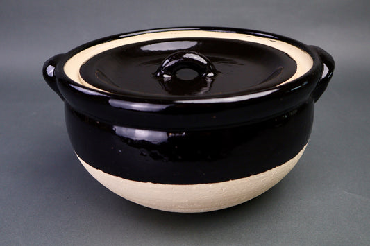black glazed ceramic rice donabe with two lids surrounded by grey background