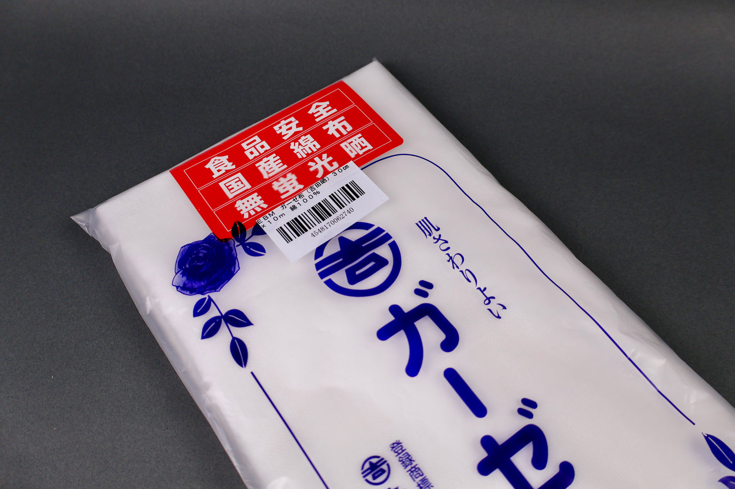 clear packaged antibacterial gauze cloth package shows blue print of hiragana and floral pattern with red product card on dark grey background