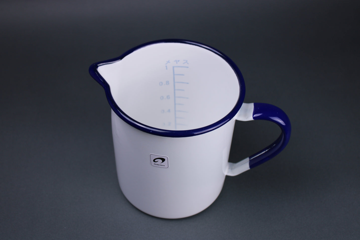 top down view of one liter measuring cup with measuring marks and numbers printed inside brand label sticker on outside of body with grey background
