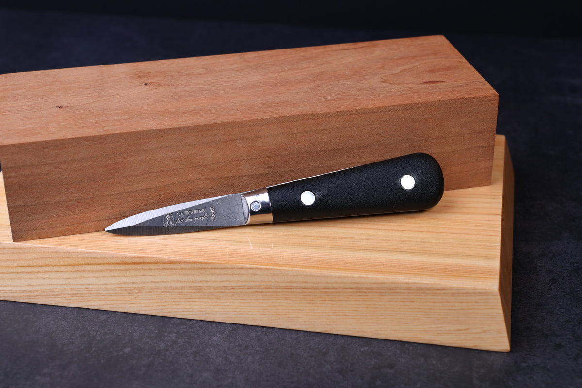 Laguiole Neron oyster knife — full side view showing blade, bolster, and handle on wood surface
