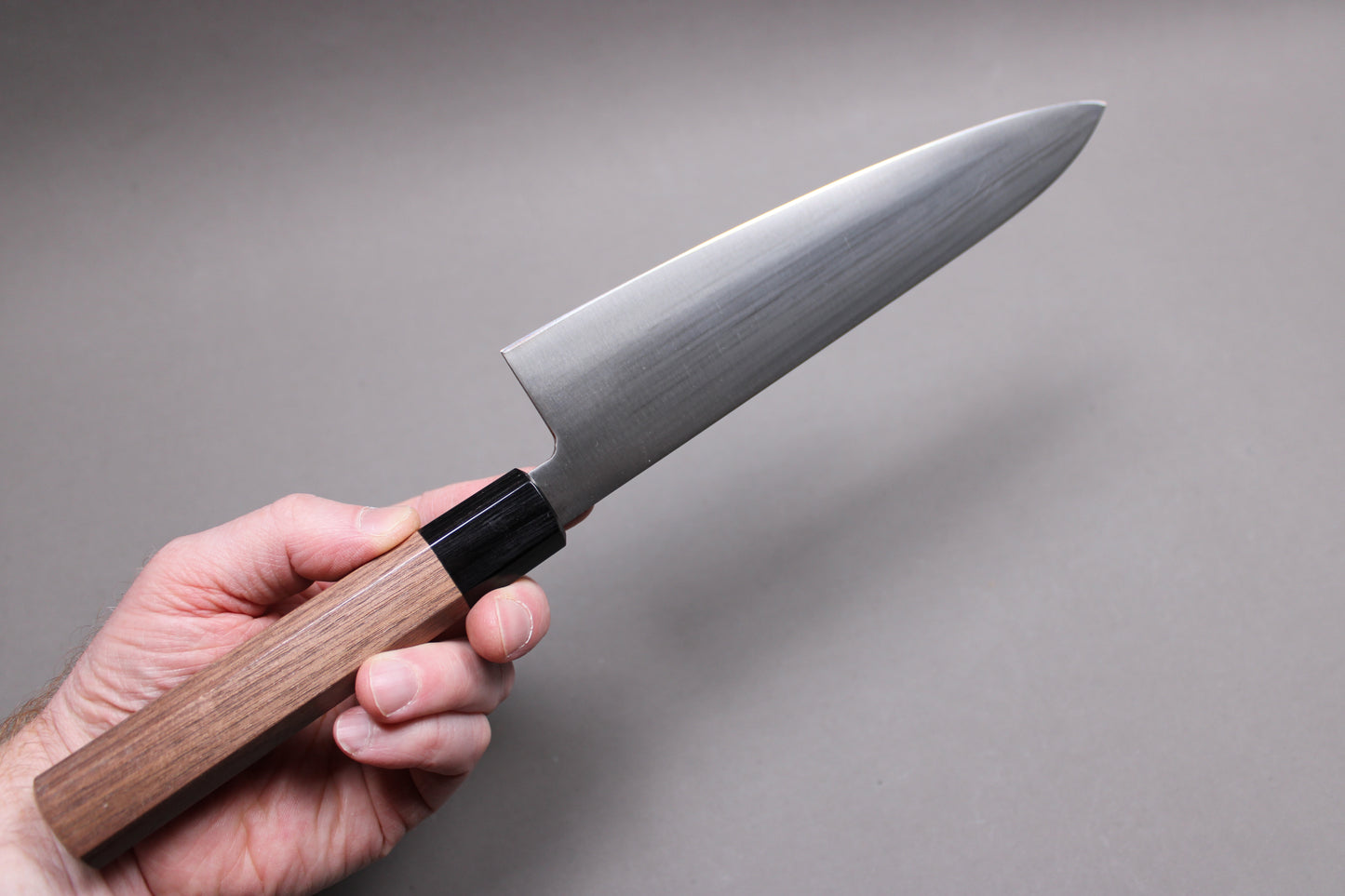 handholding knife showing backside of 210mm gyuto kawamura hamono