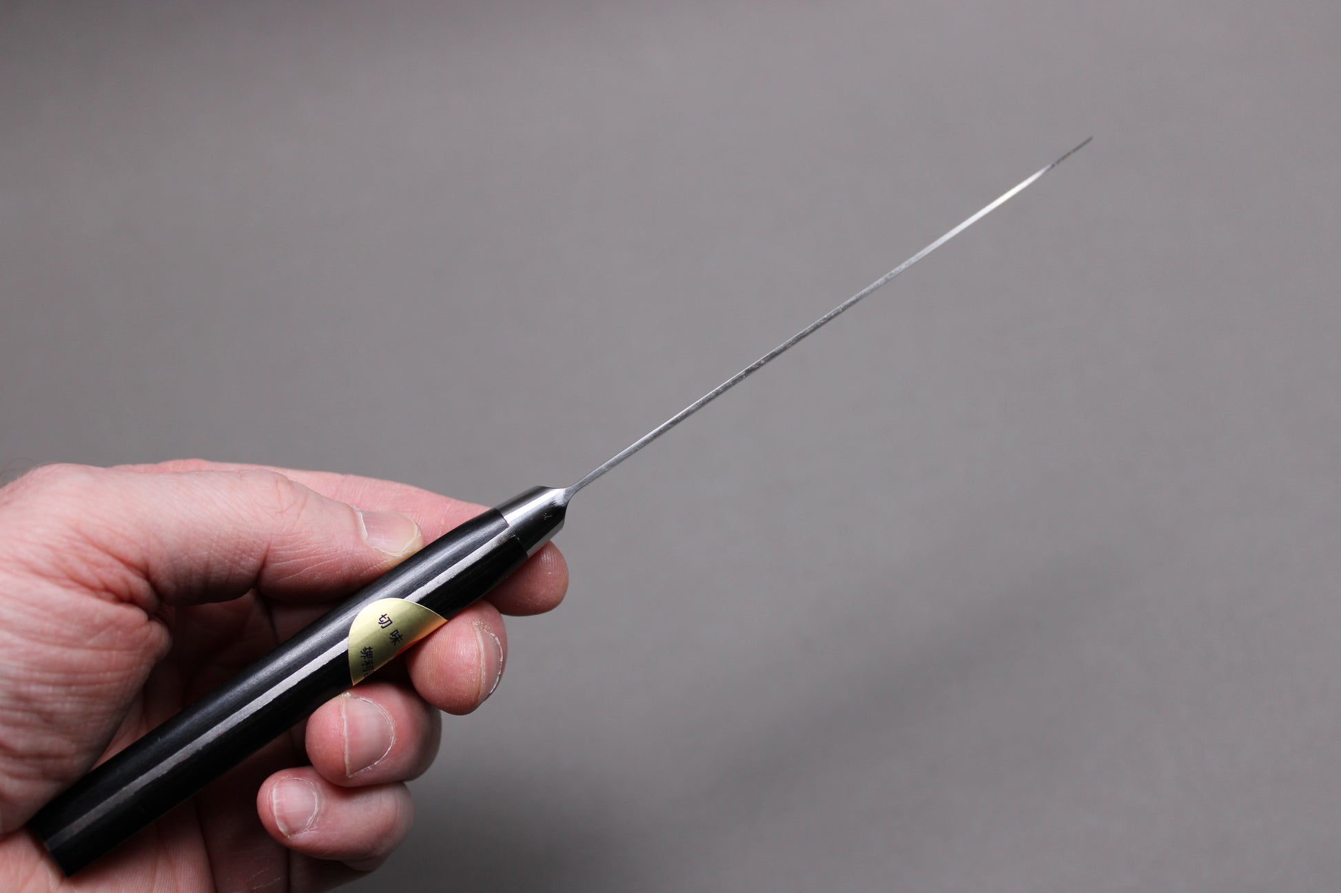 hand holding petty knife showing spine and distal tapering
