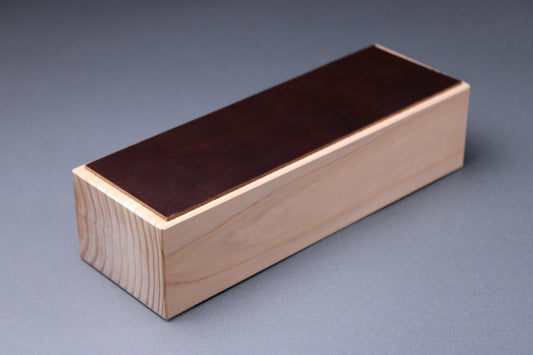 english bridle leather knife strop colored pecan deep brown mounted to tall hinoki wood yoshino base with smooth sides showing tree rings with light grey background profile shot