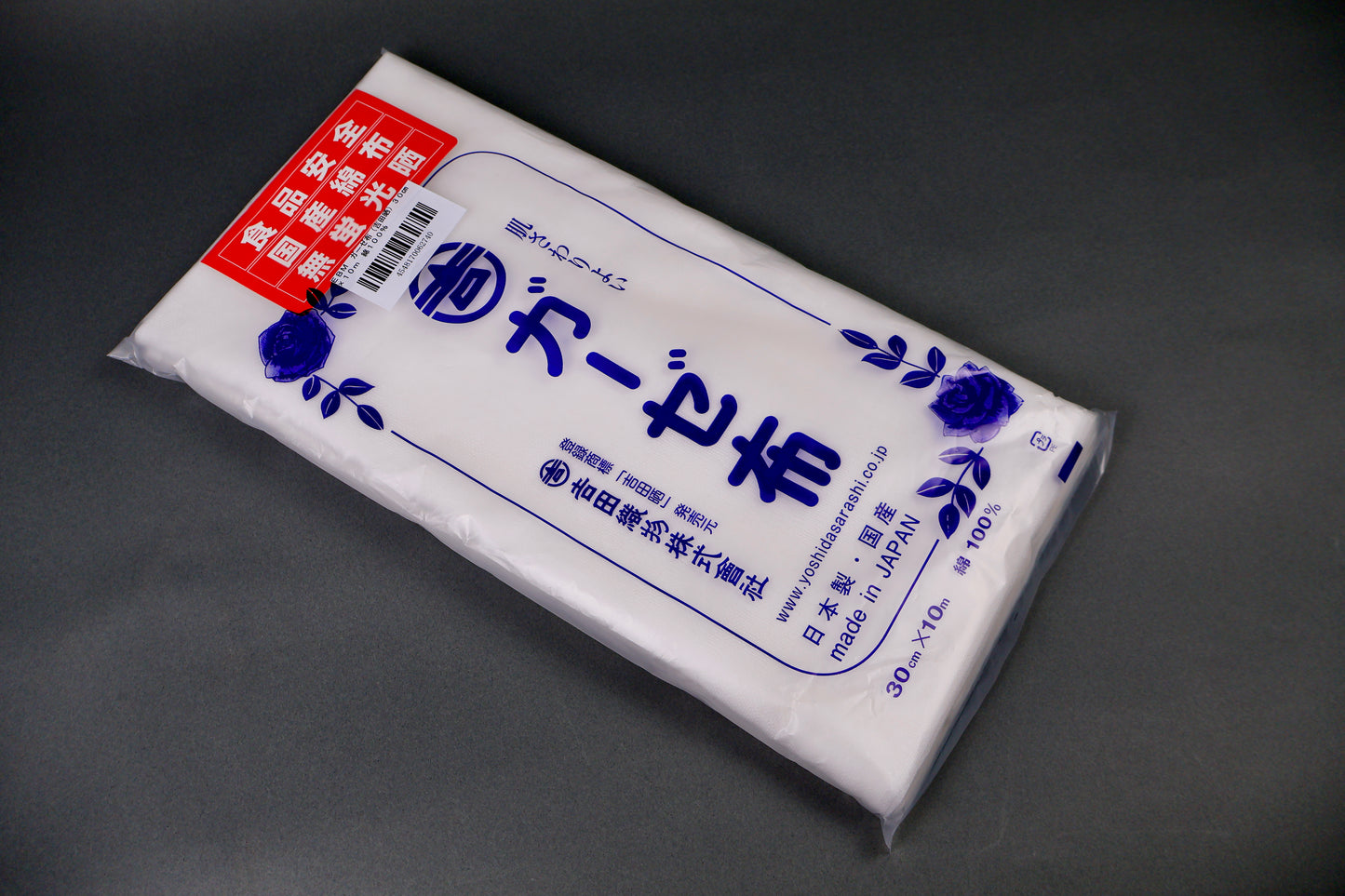 clear packaged gauze cloth package shows blue print of hiragana and floral pattern on dark grey background