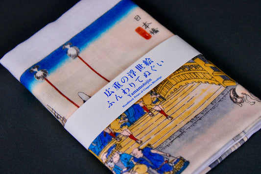 rectangular packaged tenugui towel printed with deep blue red grey classical japanese bridge on dark backdrop