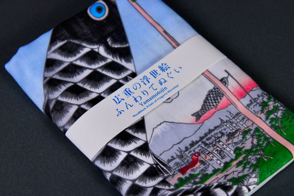 rectangular packaged tenugui towel printed with light blue red black green classical japanese carp on dark backdrop