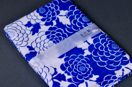rectangular packaged sarashi towel printed with blue white classic floral pattern on dark backdrop