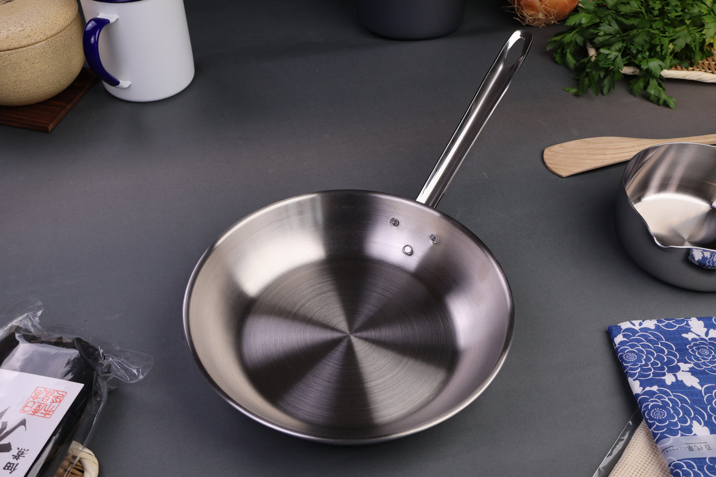 professional line saute pan three layer clad stainless steel long curved handle with kitchenware surrounding grey background