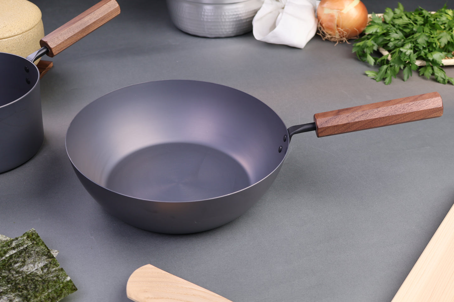 japanese nitrided iron pan with wood handle octogonal shape kitchenware surrounding with grey backdrop