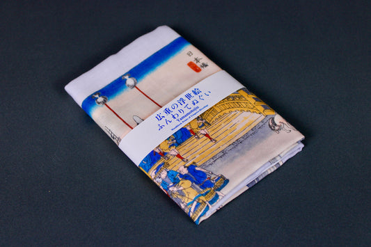 rectangular packaged tenugui towel printed with deep blue red grey classical japanese bridge on dark backdrop