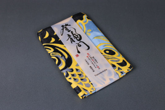 rectangular packaged sarashi towel printed with black blue grey depicting carp fish on dark backdrop