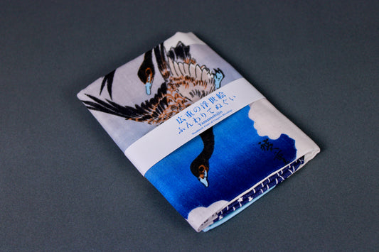 angled shot of edo period block print on cotton fabric towel showing gesse clouds and moon on grey background