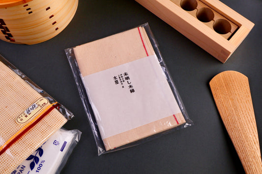 three pack of non bleached tenugui towels form Japan in plastic with kanji writing grey backdrop