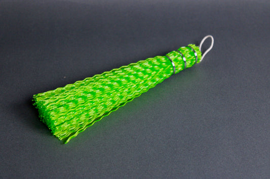 green crimped fish brush with loped white twine grey background