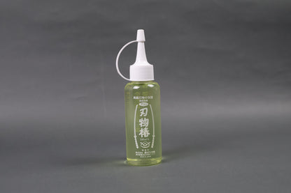 tasteless odorless high quality oil to prevent rusting oxidization on kitchen knives upright shot shimmering light yellow body screw on dropper top white with grey background