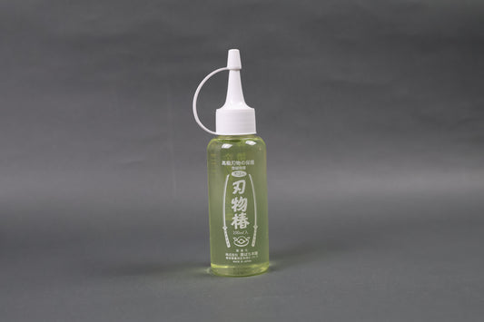 tasteless odorless high quality oil to prevent rusting oxidization on kitchen knives upright shot shimmering light yellow body screw on dropper top white with grey background
