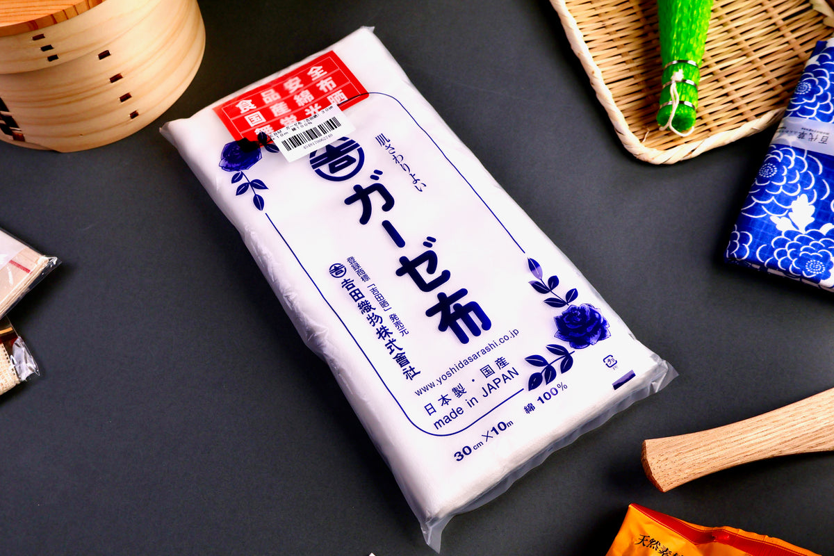 packaged white sarashi kitchen gauze with red kanji label and blue hiragana character on gey background