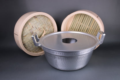 bamboo steamer kit image showing two handled aluminum pot with internal ledge holding steam ring and sitting behind shows the bamboo hinoki steamer with lid and base with grey background