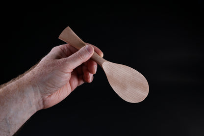 Azmaya handmade rice paddle held in hand showing size and tapered handle shape