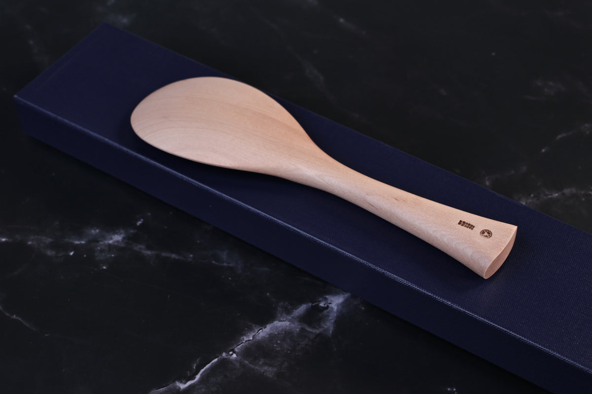 Azmaya handmade maple rice paddle laid across its navy gift box, shown at an angle with maker&