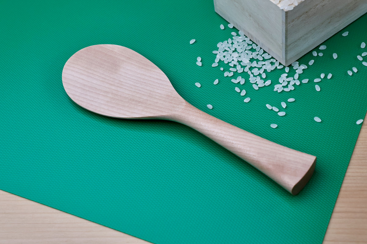 Azmaya handmade rice paddle on green mat with wooden masu box and scattered rice