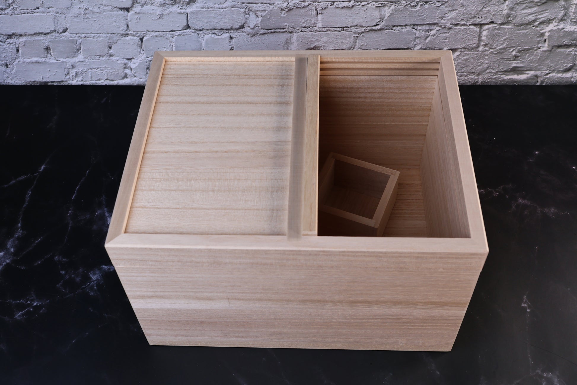 Azmaya kiri wood rice bin with one sliding lid panel open and a wooden masu measuring cup inside