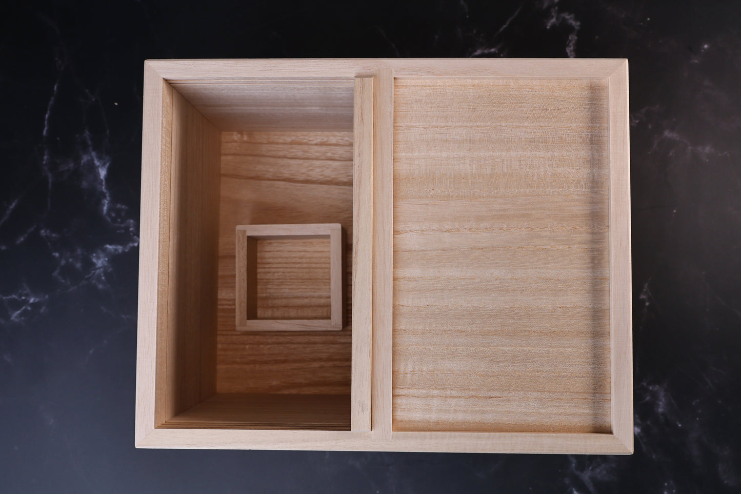 Overhead view of the Azmaya kiri wood rice bin with one side open and the masu cup inside