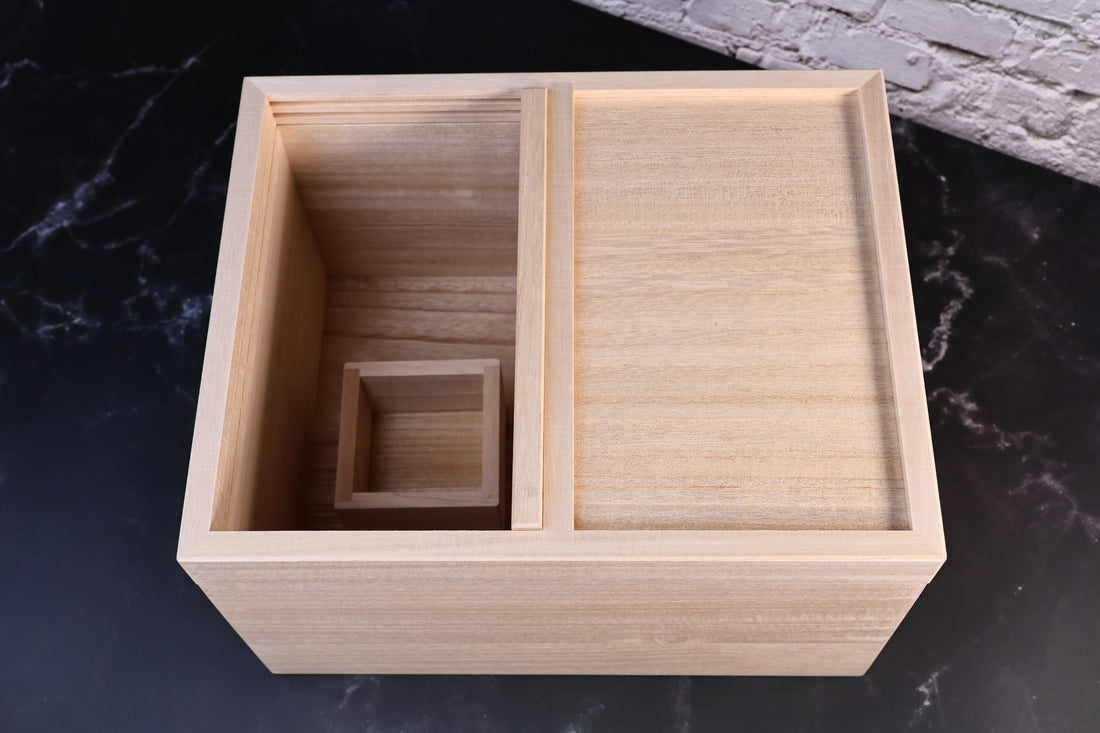 Overhead view of the Azmaya rice bin interior with the masu measuring cup set in the open compartment