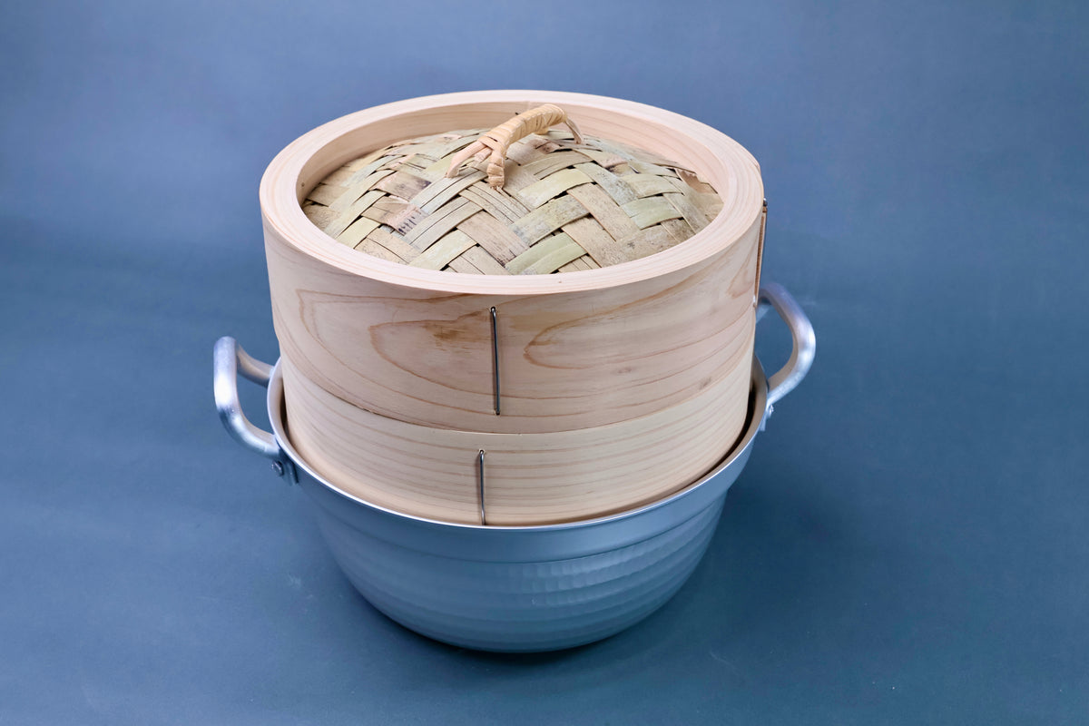 Bamboo steamer kit 21cm with dantsuki pot three-quarter view showing woven bamboo lid, cedar wood grain and hammered aluminum pot on blue-grey background