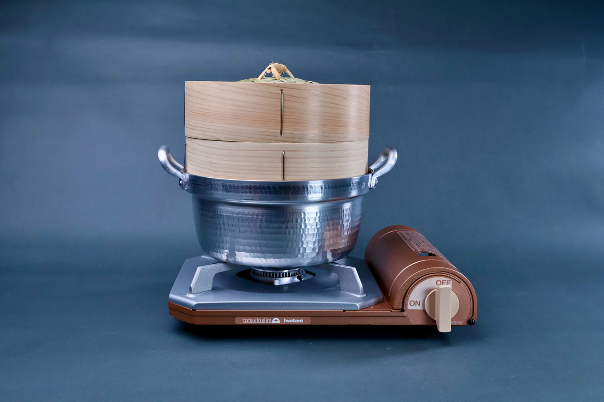 Bamboo steamer kit 21cm with dantsuki pot assembled on Iwatani portable gas burner showing cedar steamer body on blue background