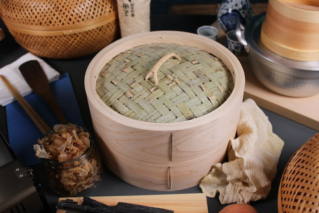  top down view dining table shot of bamboo hinoki chinese style seiro steamer with base and side of kiso hinoki surrounded by ingredients of kombu kelp shaved bonito flakes seiro steamer pot with hinoki tofu maker by yamacoh yoshino hinoki cutting board by hanabusa by tsuji wood technical