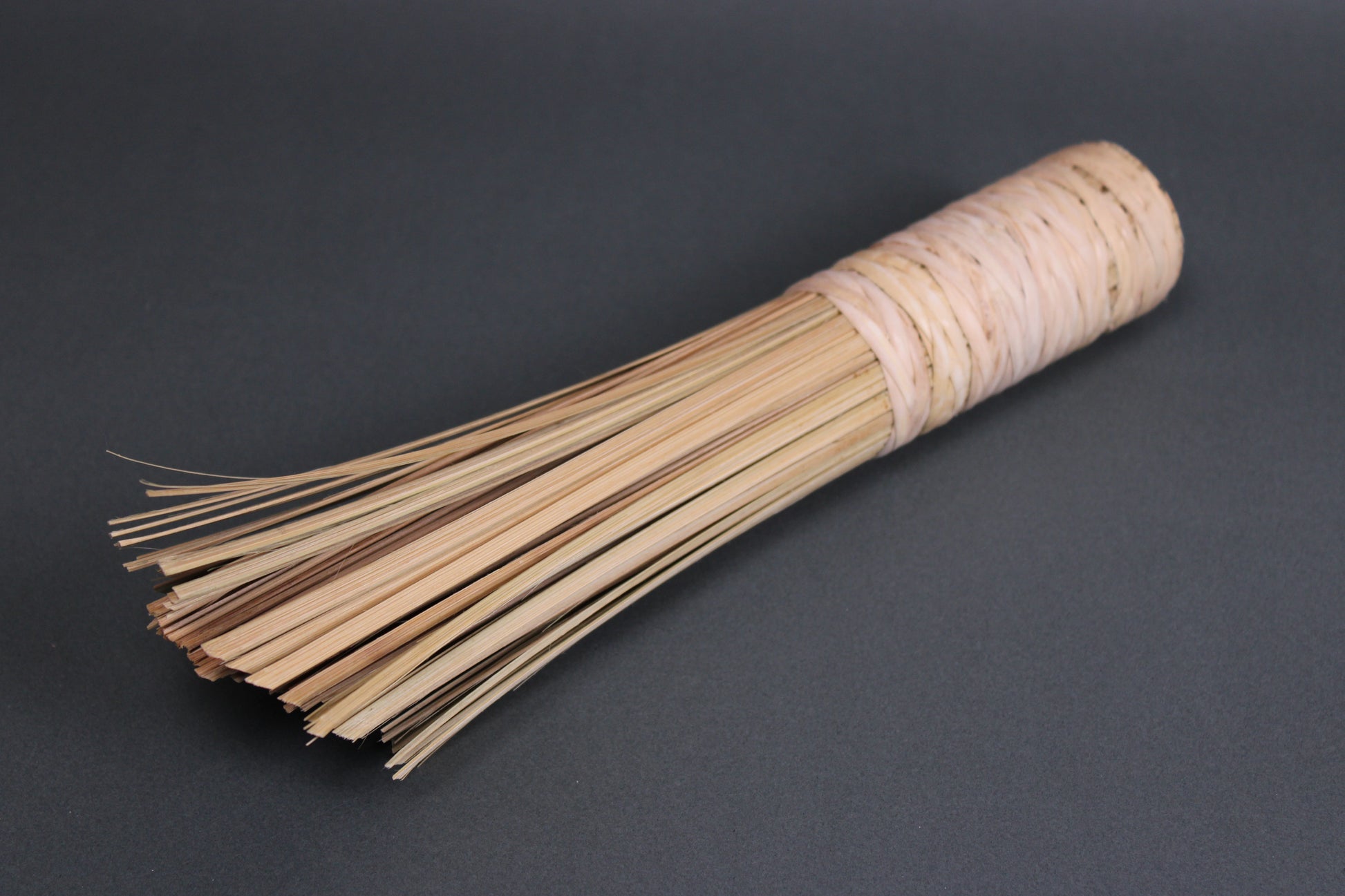 extra thick large short bamboo wok cleaning brush chan chi kee company angled shot with bristles up close grey background
