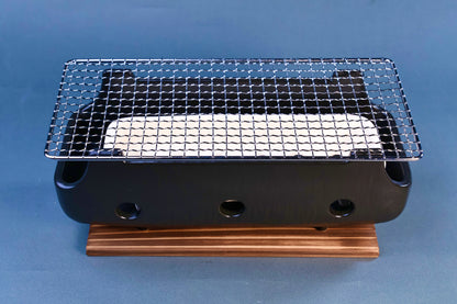 Banko yaki konro grill assembled front view showing wire grill, ceramic fire plate and ventilation holes on black ceramic body with wood base