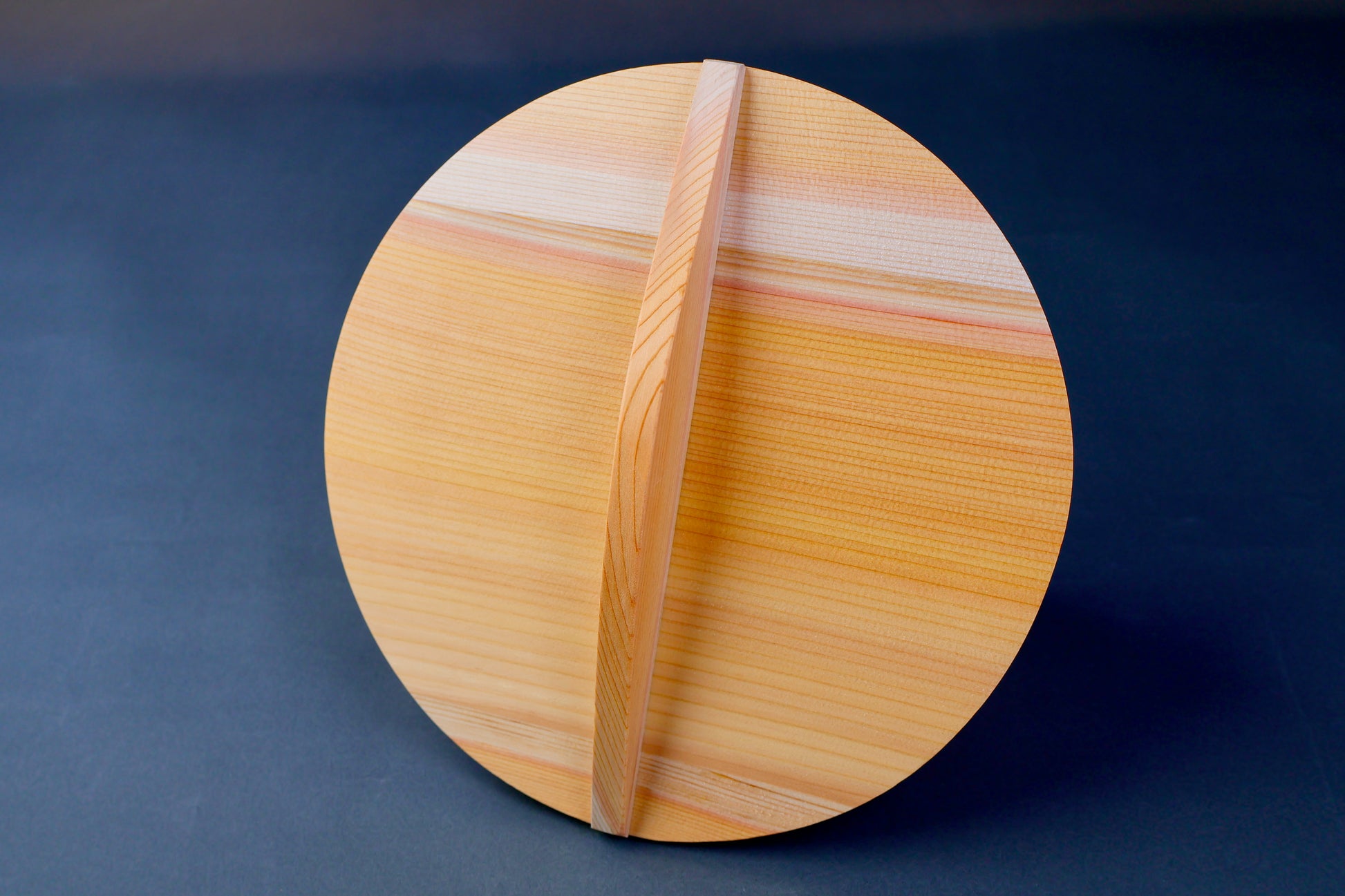 circular wooden drop lid for braising in grey background 