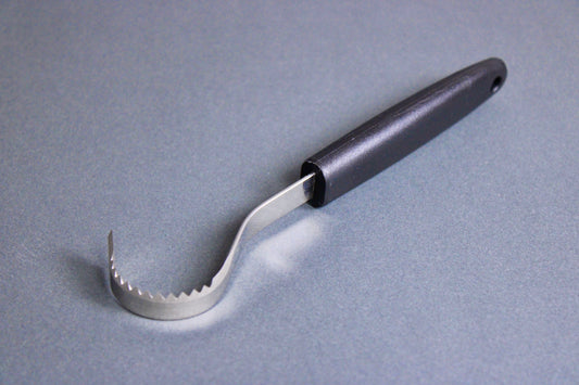 long thin black plastic handled stainless steel curved serrated tool butter curler on grey background