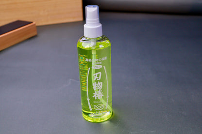 tall clear plastic spray bottle with white print hiragana sword animations with knife strop in background bluish grey backdrop